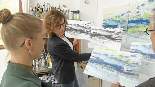 Julia Frischmann und die Amtsleitung der Stadtentwässerung stimmen sich über die Auswahl des Gemäldes für die Stellenanzeigen ab.