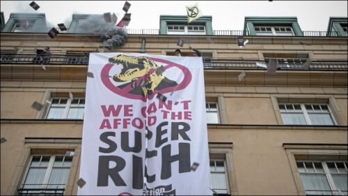 Am Ende der satirischen <em>Demo der Superreichen</em> haben Aktivisti ein großes Banner vom Hotel Adlon gedropt