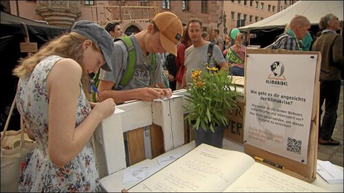 Auf dem Sebalder Platz, wo 600 Tage das Nürnberger Klimacamp stand, waren die Kirchentagsbesucher*innen eingeladen, an einer Klimabibel mitzuschreiben.
