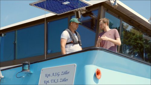 Tobias Zöller, Kapitän der Johannes von Nepomuk (rechts), im Gespräch mit einem der zwei Leichtmatrosen an einem Schleusenaufenthalt. Tobias Zöller, Kapitän der Johannes von Nepomuk (rechts), im Gespräch mit einem der zwei Leichtmatrosen an einem Schleusenaufenthalt.