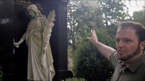 Felix Geismann steht vor dem denkmalgeschützten Grab seines Ur-Ur-Großvaters und zeigt auf die Grabstatue - eine weibliche Figur mit Palmwedel »Die Trauernde an der Tür zur Ewigkeit« – in der Familie Geismann nur »der Engel« genannt. Felix Geismann steht vor dem denkmalgeschützten Grab seines Ur-Ur-Großvaters und zeigt auf die Grabstatue - eine weibliche Figur mit Palmwedel »Die Trauernde an der Tür zur Ewigkeit« – in der Familie Geismann nur »der Engel« genannt.