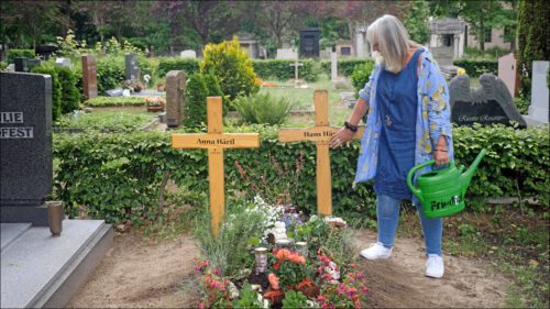 Hanne Wiest steht mit einer Gießkanne am frisch bepflanzten Grab ihrer Eltern auf dem Fürther Friedhof. Sie berührt eines der Holzkreuze und verabschiedet sich. Hanne Wiest steht mit einer Gießkanne am frisch bepflanzten Grab ihrer Eltern auf dem Fürther Friedhof. Sie berührt eines der Holzkreuze und verabschiedet sich.