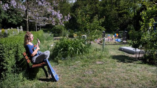 Eine junge Frau sitzt im muslimischen Grabfeld auf einer Bank, spielt Ukulele und singt ein Mantra – »warum nicht - bei der Vielfalt der Religionen, die hier schon herrscht?« Eine junge Frau sitzt im muslimischen Grabfeld auf einer Bank, spielt Ukulele und singt ein Mantra – »warum nicht - bei der Vielfalt der Religionen, die hier schon herrscht?«