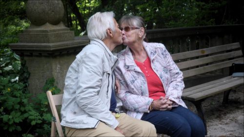 Ein älteres Ehepaar gibt sich auf einer Bank einen Kuss – die beiden erzählen, dass sie seit über fünfzig Jahren zusammen sind und kommen jeden Sonntag ins Café, »wenn das Wetter passt«. Ein älteres Ehepaar gibt sich auf einer Bank einen Kuss – die beiden erzählen, dass sie seit über fünfzig Jahren zusammen sind und kommen jeden Sonntag ins Café, »wenn das Wetter passt«.