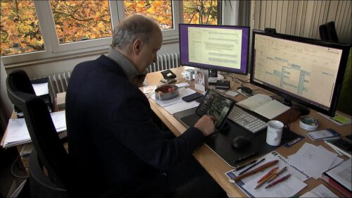 Tim Willy Weber sitzt an seinem Schreibtisch im Rathaus und telefoniert, vor ihm stehen mehrere Bildschirme und Unterlagen.