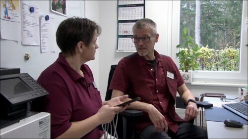 Zwei Mitarbeitende des Seniorenzentrums Gottfried Seiler besprechen die KI-gestützte Dokumentations-App: Per Spracheingabe ins Smartphone erfassen Pflegekräfte ihre Tätigkeiten direkt am Bewohnerzimmer – das spart bis zu 25 Minuten Dokumentationszeit pro Schicht.