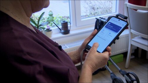 Eine Pflegekraft hält ein Smartphone mit der KI-Dokumentations-App in der Hand – die Spracherkennung wandelt gesprochene Einträge automatisch in strukturierte Pflegedokumentation um und steht sofort allen Kolleginnen und Kollegen zur Verfügung.